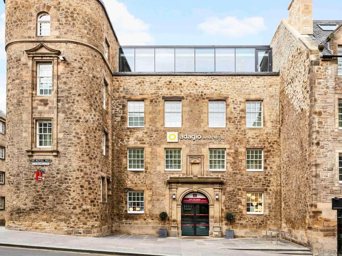 a large brick building with a red door at Aparthotel Adagio Edinburgh Royal Mile in Edinburgh
