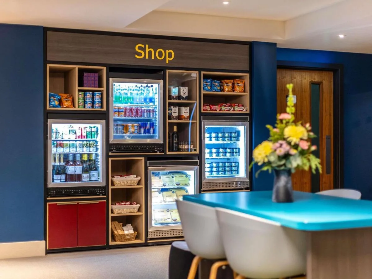 a shop with a table and a refrigerator at Aparthotel Adagio Edinburgh Royal Mile in Edinburgh