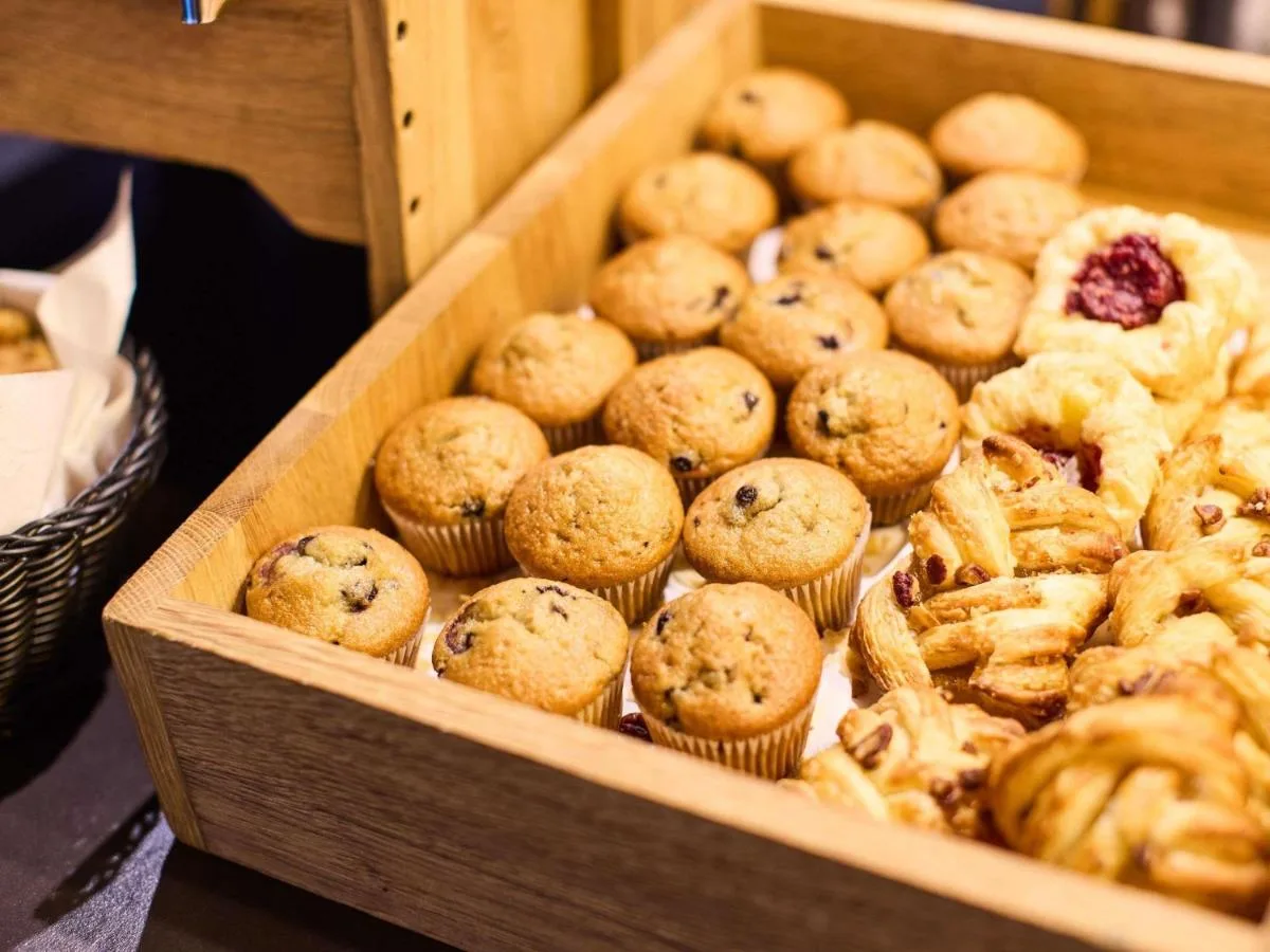 a wooden box filled with muffins and other pastries at Aparthotel Adagio Edinburgh Royal Mile in Edinburgh